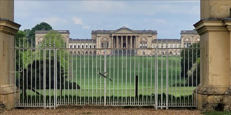 A very large and grand building seen from behind gates, Stowe school